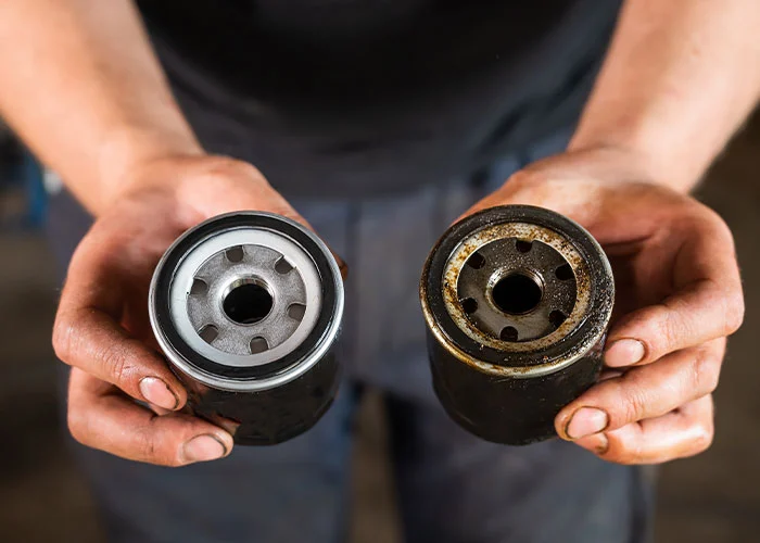 Hands holding two oil filters