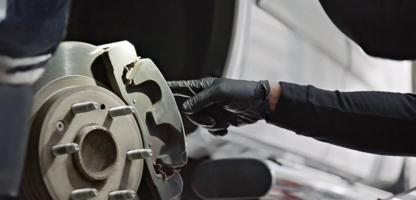 Technician handling a brake disc and caliper