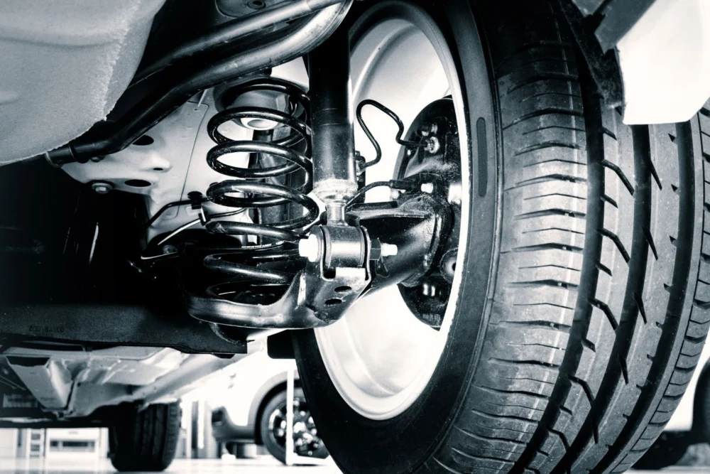 Coil spring and shock absorber behind a car wheel